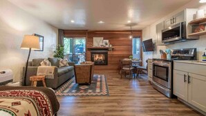 A living room with a fireplace, a dining area, and a kitchen with modern appliances. - Kings Beach Studio • Pool, Hot Tub, SUP, & Sauna • Kings Beach & Northstar (Tahoe Vista)