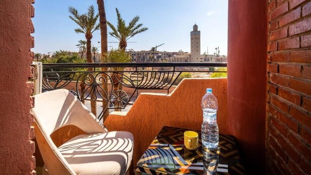 A balcony with a chair, a table, and a bottle of water.