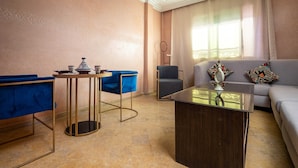 A modern living room with a sofa, a coffee table, and two blue chairs.