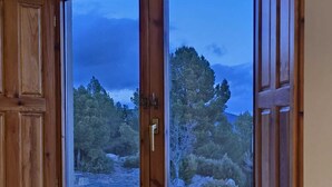 A wooden cabinet with two glass doors, each displaying a view of a rocky landscape with trees. - LA CILLA MORATALLA (Moratalla)