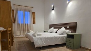 A hotel room with a bed, two bedside tables, a wooden wardrobe, and a window with curtains. - LA CILLA MORATALLA (Moratalla)