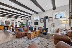 A spacious living room with a fireplace, leather sofas, a wooden coffee table, and a large rug. - Beautiful 4 bedroom home with loft in downtown Coeur d'Alene (Coeur d'Alene)