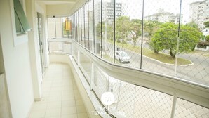 A balcony with a view of a street and buildings. - Apartamento Centro de Imbituba - SC (Imbituba)