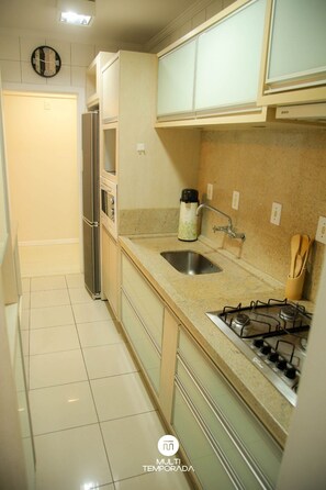 Apartamento premium | Cozinha privada | Geladeira, talheres/pratos/utensílios de cozinha, mesas de jantar