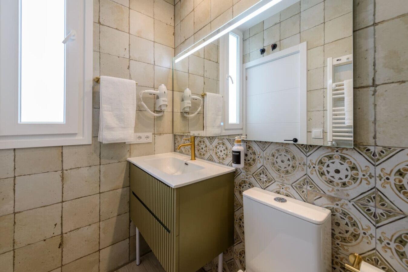 A bathroom with a sink, mirror, towel rack, and toilet.