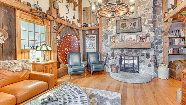 A cozy living room with a stone fireplace, leather furniture, and rustic decor. - Dalton Retreat w Deck and Fire Pit (Dalton)