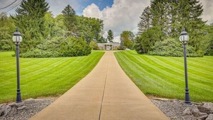 A straight pathway leading to a building with a symmetrical lawn on either side, flanked by two street lamps. - Dalton Retreat w Deck and Fire Pit (Dalton)