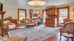 A traditional living room with a large rug, wooden furniture, and a chandelier. - Dalton Retreat w Deck and Fire Pit (Dalton)