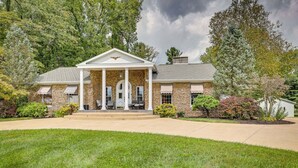 A large, two-story building with a central entrance flanked by columns, a stone facade, and a covered porch. - Dalton Retreat w Deck and Fire Pit (Dalton)