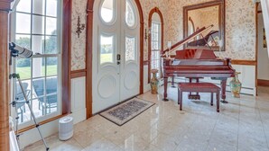 A grand piano in a spacious room with large arched doors and a view of a garden. - Dalton Retreat w Deck and Fire Pit (Dalton)