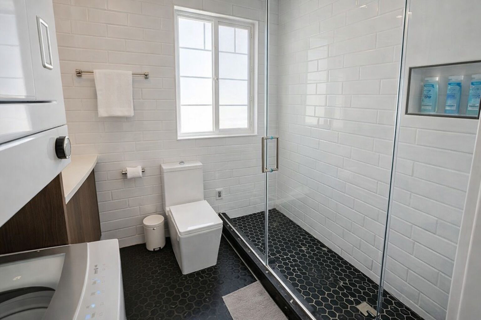 A modern bathroom with a toilet, sink, and shower area.