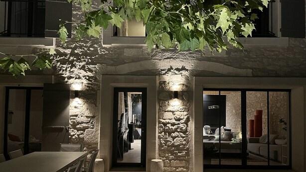 A stone facade with a modern interior, including a dining area and a living space with a sofa and a coffee table. - Mas provençal, renovated by an architect, heated swimming pool. St Rémy de Provence (St Remy de provence)