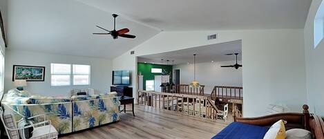 A spacious living area with a sofa, a bed, and a dining table.