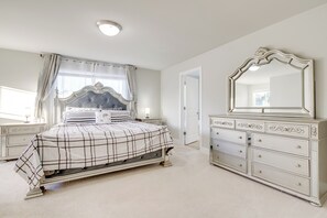 A bedroom with a bed, dresser, and mirror.
