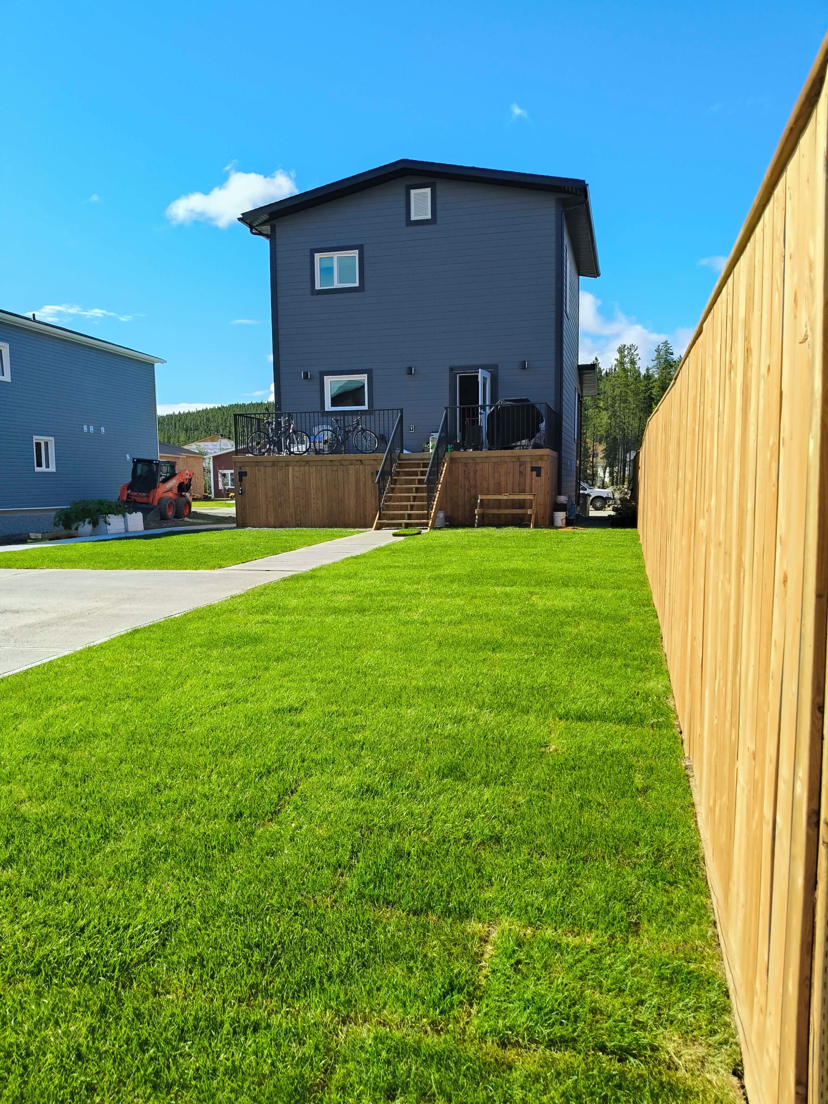 A residential building with a flat roof, a front entrance, and a visible staircase leading to the entrance.