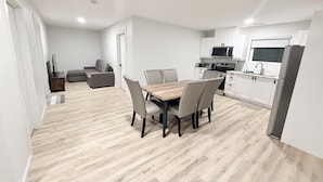 Un apartament modern amb zona de menjador, cuina i espai de sala d'estar.