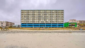 Un edificio a più piani, con la parte inferiore blu e la parte superiore color beige, probabilmente un hotel o un complesso di appartamenti.
