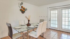 A dining area with a glass table, white chairs, and a decorative vase. - Hike & Fish! Wooded Family Getaway in Interlachen (Interlachen)