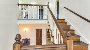 A wooden staircase with white balusters and a handrail, leading to an upper floor.