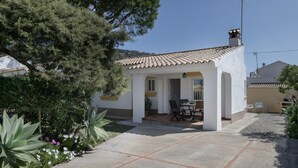 A house with a tiled roof, a patio with chairs, and a large tree. - Rural House 'Casas Pepe 2' with Private Terrace, Wi-Fi, and Air Conditioning (Los Caños de Meca)