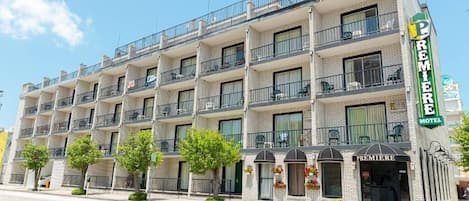 A multi-story hotel with balconies, a prominent "Premiere Motel" sign, and a ground-level entrance with awnings.