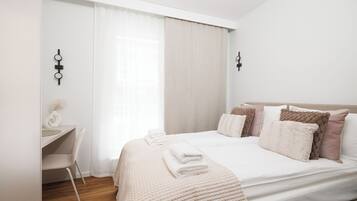 A modern bedroom with a bed, bedside tables, and a desk.