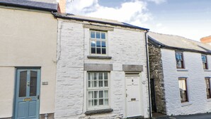 A row of white buildings with a blue door and a window with shutters. - Cariad Cottage (Hereford)