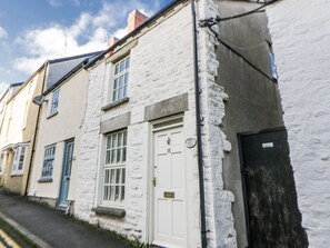A row of white buildings with a white door and windows, a black door, and a visible number '16' on the door. - Cariad Cottage (Hereford)