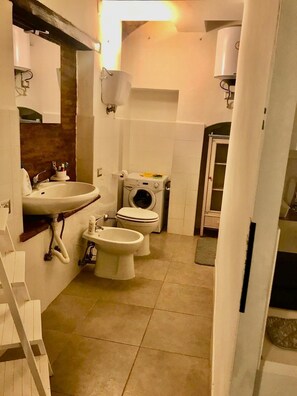 A compact bathroom with a sink, two toilets, a washing machine, and a shower area. - APARTMENT IN THE HISTORIC CENTRE OF FOLIGNO (Foligno)