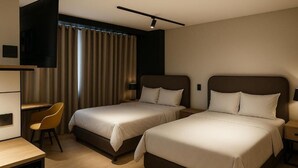 A hotel room with two beds, a desk, a chair, and a TV. - Hotel Nuit by ilar (Bogotá)