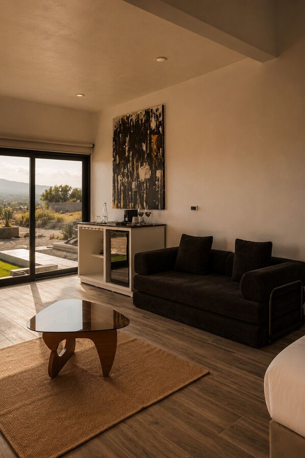 A modern living room with a dark sofa, a glass coffee table, and a large abstract painting on the wall. - SED DE VALLE-VALLE DE GUADALUPE (Valle de Guadalupe)