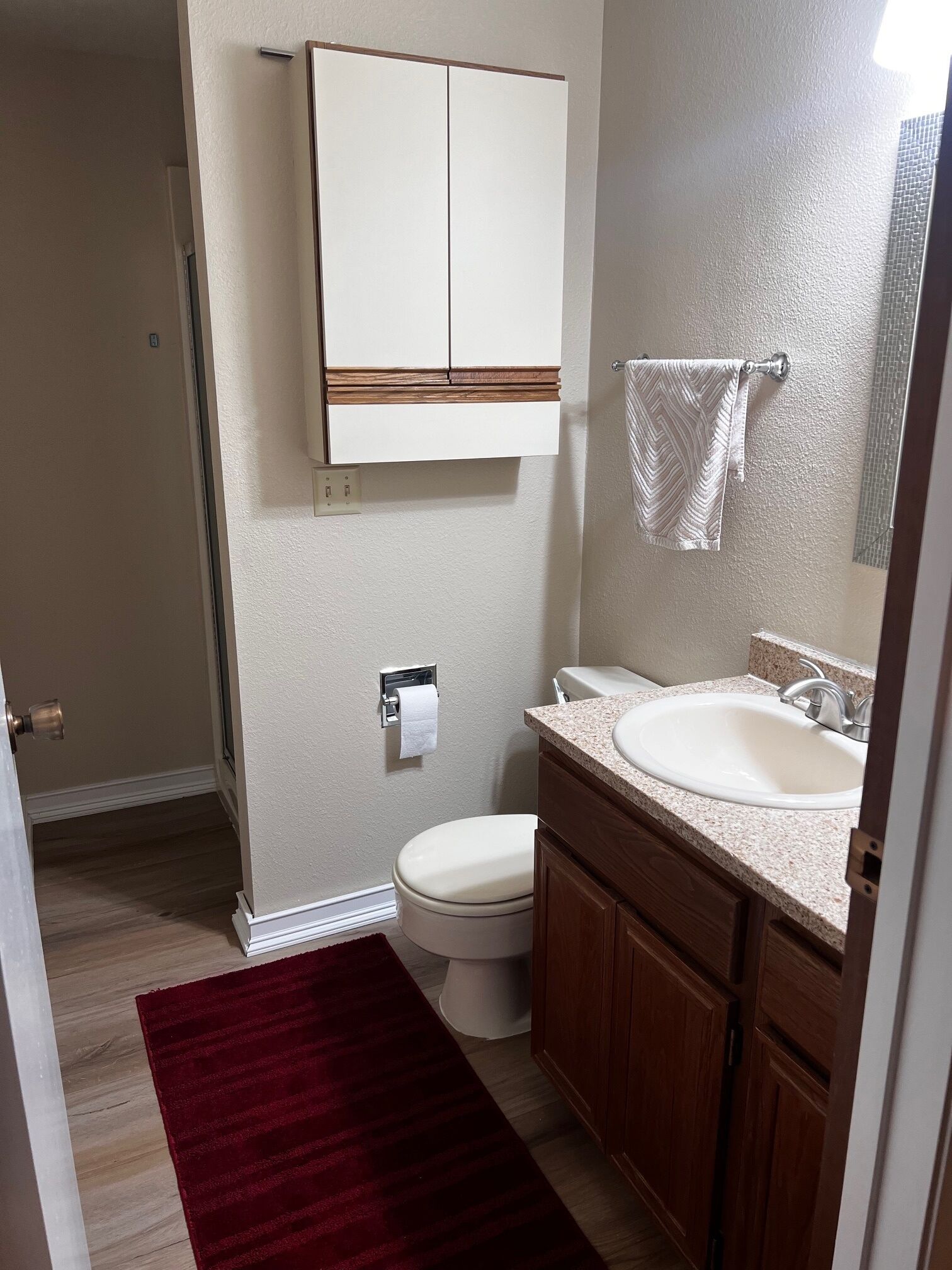 Une salle de bain avec des toilettes, un lavabo et un meuble de rangement.