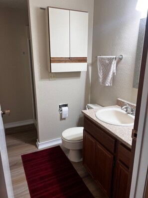 Ein Badezimmer mit Toilette, Waschbecken und Schrank.