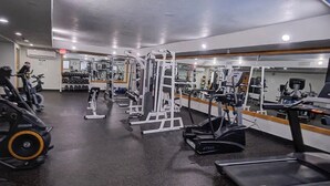 Ein Fitnessstudio mit Laufbändern, Kraftgeräten und Kurzhanteln.