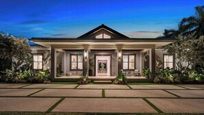 A modern two-story house with a symmetrical facade, large windows, and a well-maintained lawn. - 1-Acre Oasis: Pool/Spa, Pickleball, Bball & More (Miami)