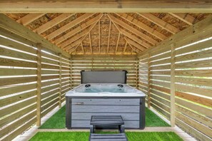 A hot tub under a wooden structure with a slatted roof and a bench in front. - 3BR Pet-Friendly Retreat Near DT + Hot Tub (Cleveland)