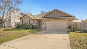 A single-story house with a garage, a brick exterior, and a front yard. - Beach Haven: 6 Beds, Pet Friendly, 8miles to Beach (Mary Esther)