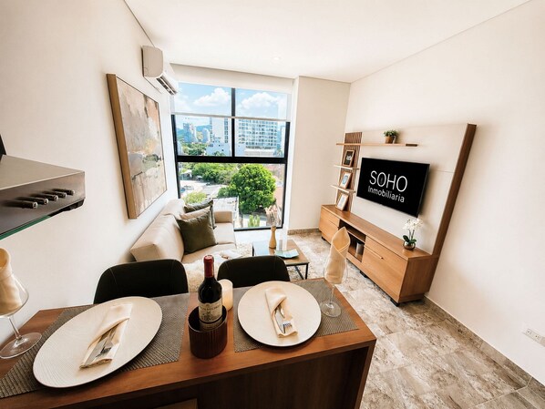 A modern living room with a dining area, a TV, and a view of the city.