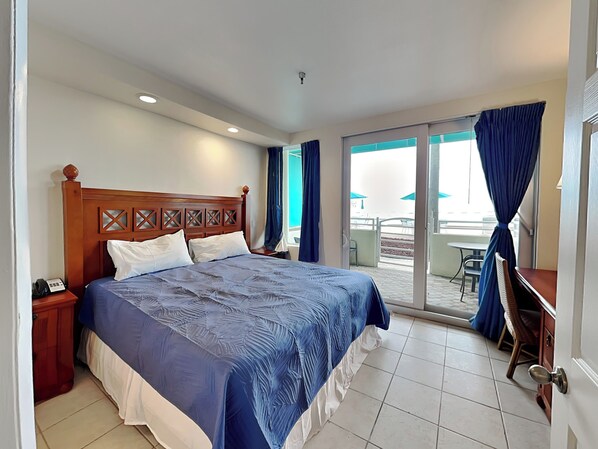Une chambre d’hôtel avec un grand lit, un bureau et une vue sur l’espace extérieur.