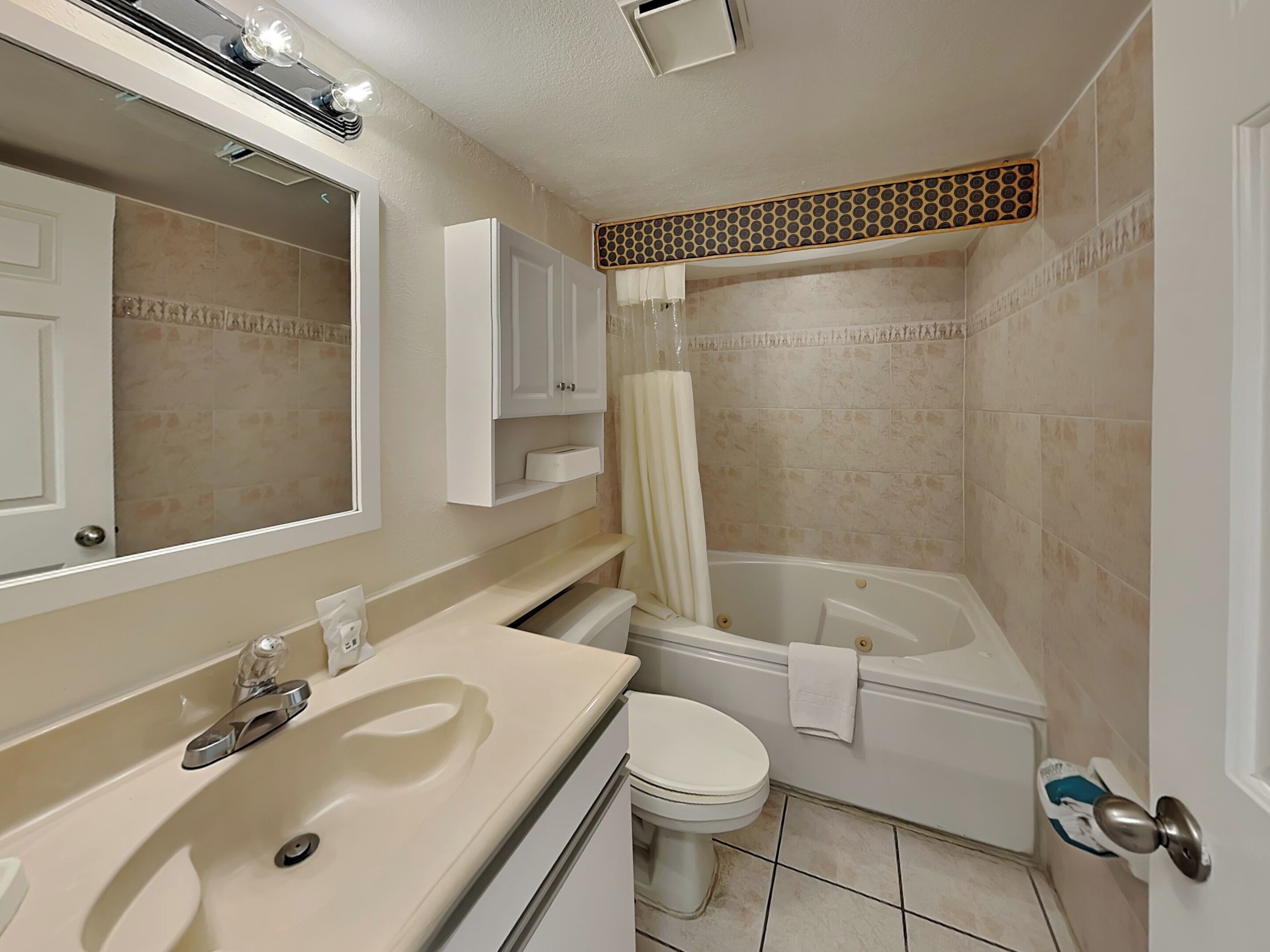 Un baño con lavamanos, espejo, inodoro y bañera.