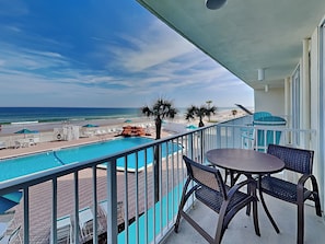 A balcony with a view of the ocean, a pool, and outdoor seating. - Harbour Beach Resort 203 (Daytona Beach)