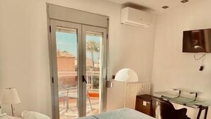 A hotel room with a bed, a desk, a chair, and a TV. - Red House Rooms  (Llucmajor)