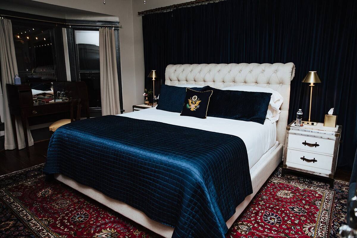 Een slaapkamer met een groot bed, een bureau en een stoel.