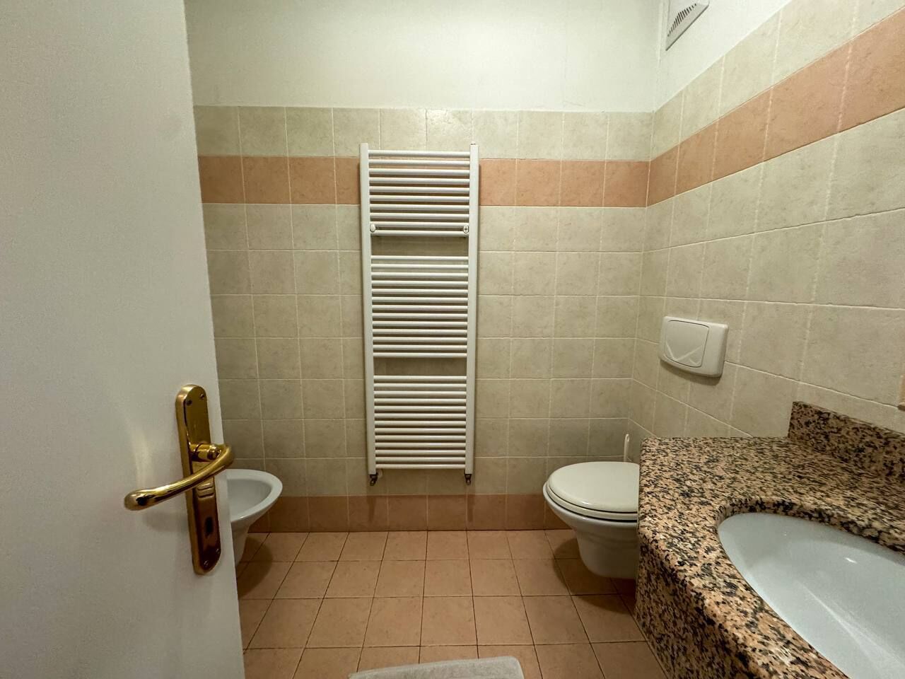 Casa de banho com sanita, bidé e lavatório.