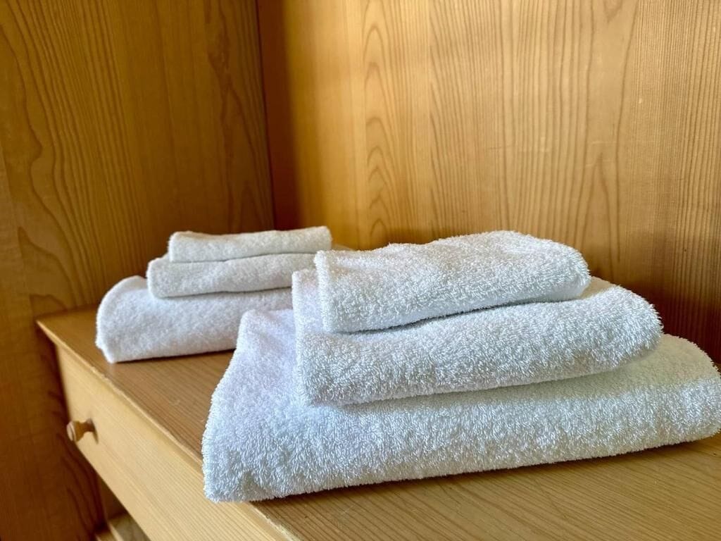 Ein Stapel weiße Handtücher auf einer Holzbodenfläche.