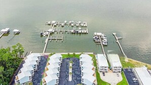 An aerial view of a marina with docked boats and a row of white-roofed buildings with outdoor seating. - Completely Renovated Jan 2026 - Bring the Boat! (Orange Beach)