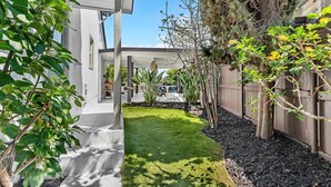 A well-maintained garden with a lawn, various shrubs, and a wooden fence. - *NEW San Diego Home-Private Hot Tub & Views+Pet (San Diego)
