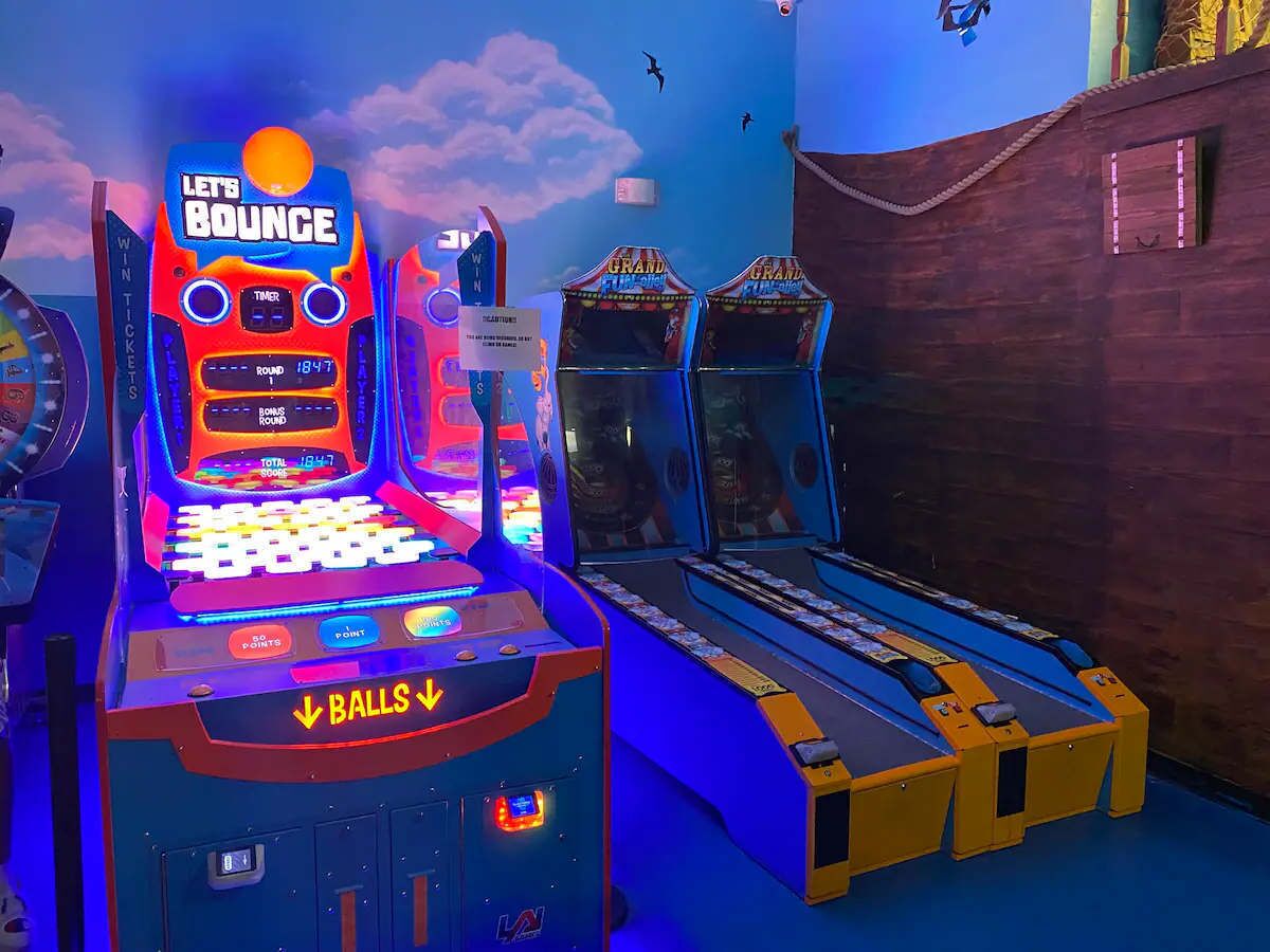 A pinball machine with a 'Let's Bounce' sign, a timer, and a track for balls to move along.