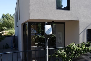 A modern building with a white exterior, a large window, and a security camera mounted on a pole. - Luxury Villa Casa Tia with Pool, Jacuzzi, Sauna (Porec)