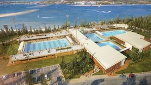 An aerial view of a swimming complex with multiple pools and a large building. - Broadwater Waterfront Balcony near Sea World (Labrador)